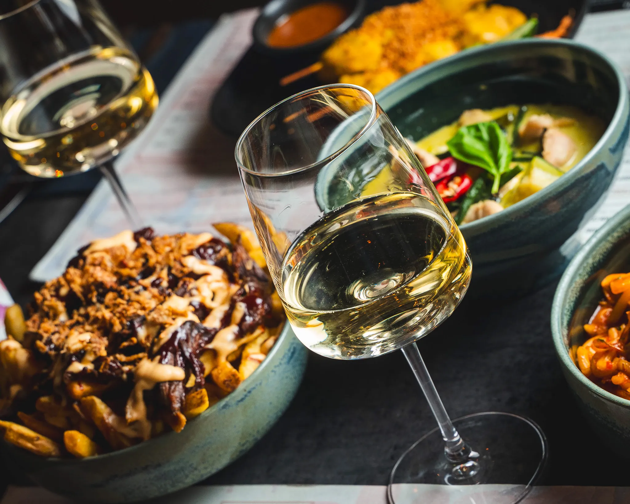 White wine beside curries and sharing plates at Lotus.